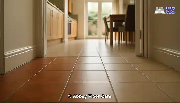 Wide-angle view through a UK home showing a tiled hallway and tiled kitchen-diner with different tile styles, all clean and even.